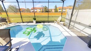 A swimming pool with a green inflatable turtle float, a yellow inflatable ring, and a small potted plant. - Bella Vida - 470 Las Fuentes Dr (Kissimmee)