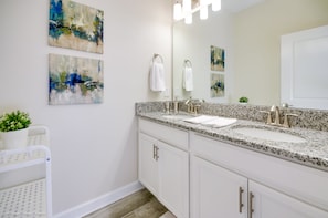 A modern bathroom with a double sink, white cabinets, and abstract art on the walls. - Storey Lake - 4883 Romeo Circle (Kissimmee)