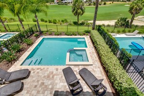 A swimming pool with lounge chairs, a hot tub, and a view of a golf course. - Reunion Resort and Spa - 1080 Castle Pines Ct (Kissimmee)