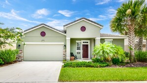 A two-story house with a garage, a front porch, and a well-maintained lawn. - Solterra - 4175 Oaktree Drive (Davenport)
