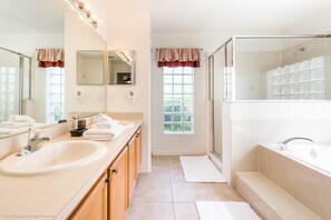 A bathroom with a large vanity, a bathtub, and a shower area. - Legacy Park - 908 Coventry Road (Davenport)