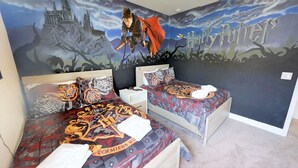 A bedroom with two beds, each with themed bedding and a large wall mural of a castle and a character. - Encore Resort at Reunion - 7521 Marker Avenue (Kissimmee)