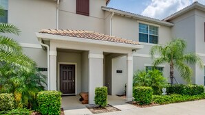 A two-story residential building with a beige facade, a tiled roof, and a front porch. - Storey Lake - 3175 Pequod Place (Kissimmee)