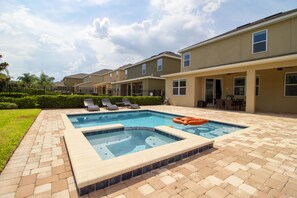 A swimming pool with a hot tub, lounge chairs, and a patio area with a brick floor. - Encore Resort at Reunion - 791 Lasso Drive (Kissimmee)