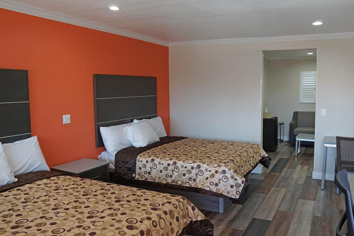 Een hotelkamer met twee bedden, een bureau en een stoel.