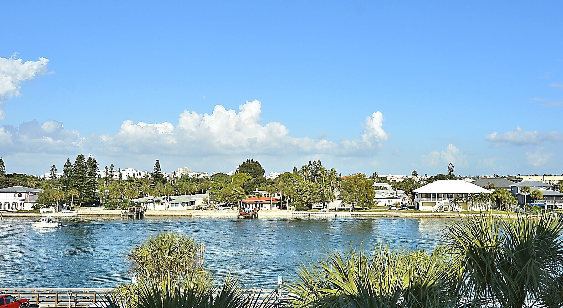 A waterfront property with a dock, a marina, and a view of the cityscape.