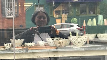 A storefront with wicker baskets and a car parked outside.
