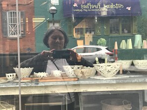 Une devanture de magasin avec des paniers en osier et une voiture garée devant.