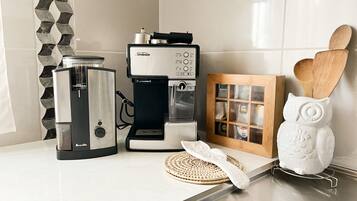 A kitchen with a coffee maker, a scale, and a framed box of tea bags.