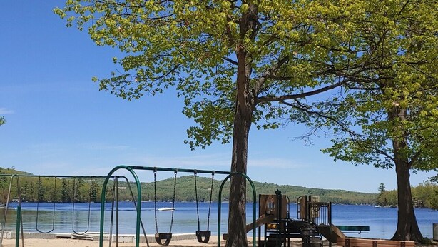 A park with a swing set and benches by a lake. - Swim, Kayak,  lawn games. Walk to ice cream. Live Theatre , firepit smores!  (Harrison)
