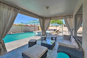 A covered outdoor area with a pool, wicker furniture, and umbrellas. - Central Lake Havasu City House: Grill & EV Charger (Lake Havasu City)