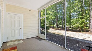 A room with a large sliding glass door leading to a wooded area. - 314 Willow Bend - Barefoot Resort Rentals (North Myrtle Beach)