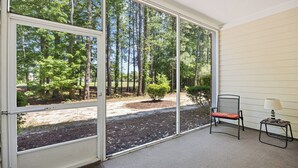 A room with a large sliding glass door leading to a forested area. - 314 Willow Bend - Barefoot Resort Rentals (North Myrtle Beach)