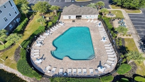 An aerial view of a swimming pool surrounded by lounge chairs and a small building. - 314 Willow Bend - Barefoot Resort Rentals (North Myrtle Beach)