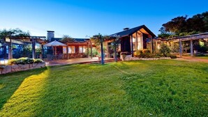 A modern house with a well-maintained lawn and outdoor seating area. - Stunning Ranch Home with Ocean Views (Carmel)