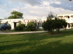 Houses with front porches and garages line a tree-lined street.