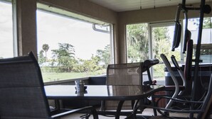 A patio area with a table and chairs, overlooking a garden. - Beautiful Vacation Home Across from Lake Okeechobee (Okeechobee)