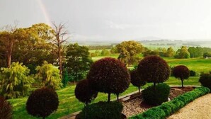 Un jardin aménagé avec des haies soigneusement taillées et une variété d’arbres.
