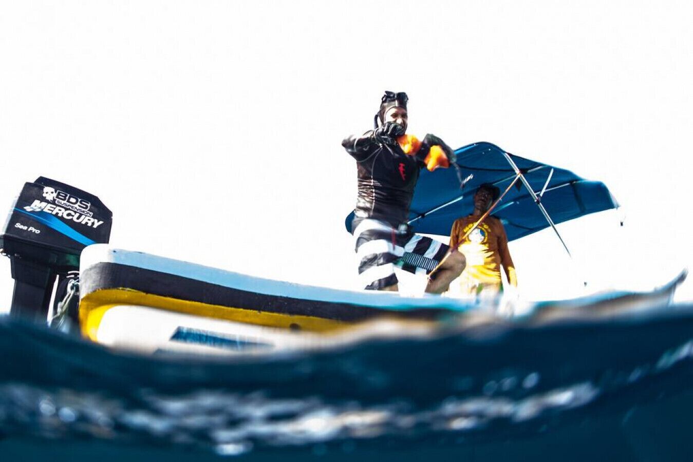 A boat with a visible outboard motor labeled 'Eds Mercury' and a person wearing a life jacket.