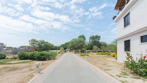 A paved pathway leading to a white building with a window. - Beach Townhouse with Private Parking (San Jacinto)