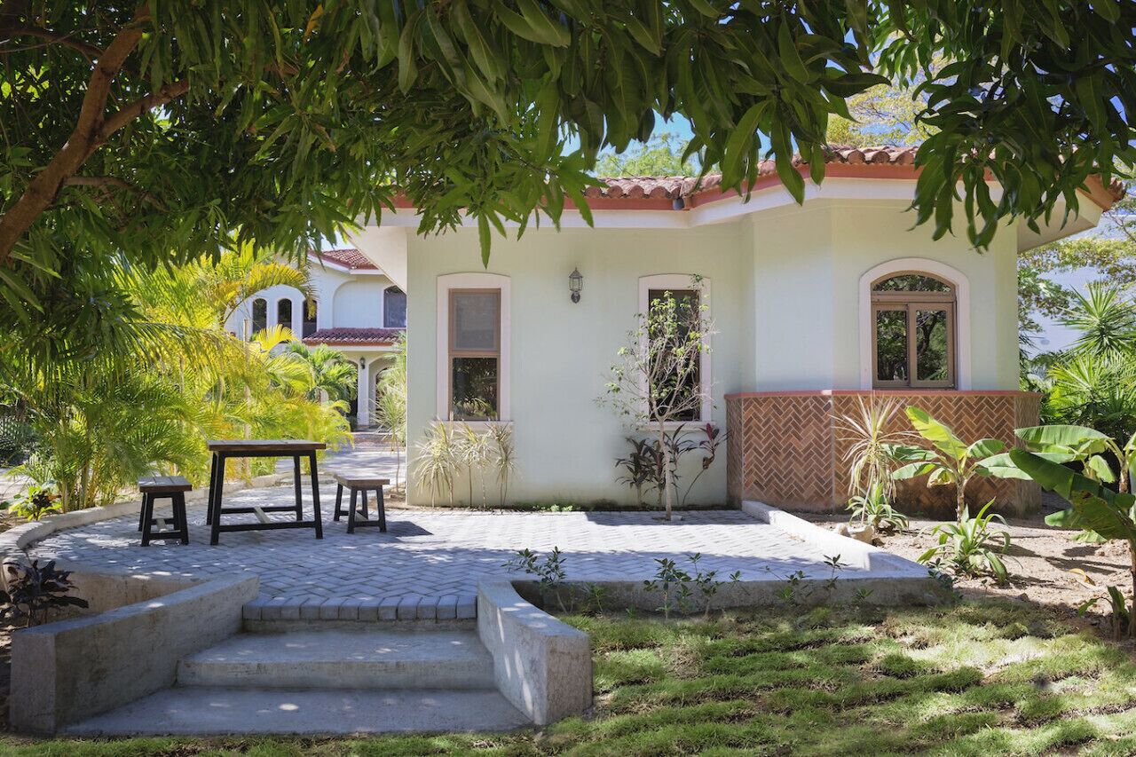 A house with a patio, steps leading to the entrance, and a small garden area.