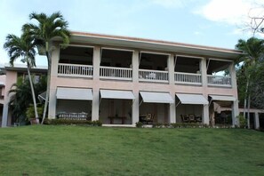 A two-story building with a flat roof, multiple balconies, and awnings. - Spectacular Location, Luxurious Villa, at Dorado Beach Ritz-Carlton Reserve (Dorado)