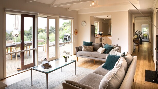 A spacious living room with a sofa, coffee table, and a view of the outdoors.