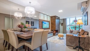 A modern living room with a dining area, a fireplace, and a television. - Comfort and Nature 1.2km from the Center of Gramado (Gramado)