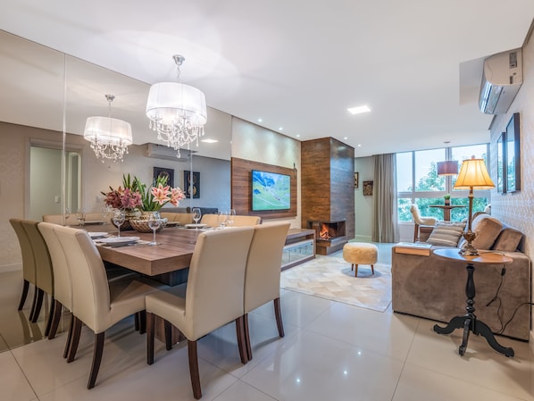 Una sala de estar moderna con comedor, chimenea y televisor.
