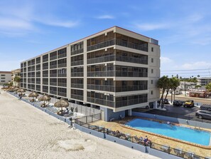 Un hôtel à plusieurs étages doté d’une piscine, d’un salon de plage et offrant une vue sur l’océan.