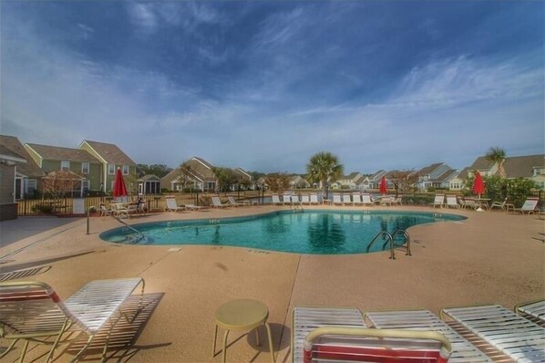 Relax by the pool surrounded by comfortable lounge chairs and umbrellas.
