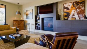 A modern living room with a fireplace, a large abstract painting, and a comfortable seating area. - Modern Sonoma Home! Beautiful Views, Hot Tub.  Relax on The Patio, Wine Country! (Sonoma)
