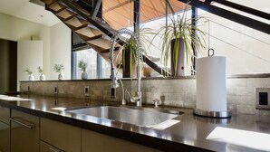 A modern kitchen with a stainless steel sink, a built-in oven, and a large window overlooking a staircase. - Modern Sonoma Home! Beautiful Views, Hot Tub.  Relax on The Patio, Wine Country! (Sonoma)