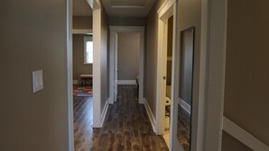 A hallway with wooden flooring, white trim, and a ceiling light. - 3 Br Disneyland Home — Sleeps 6-8 (Anaheim)