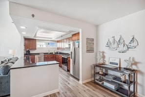 Une cuisine moderne avec des meubles en bois, des appareils électroménagers en acier inoxydable et un îlot central.