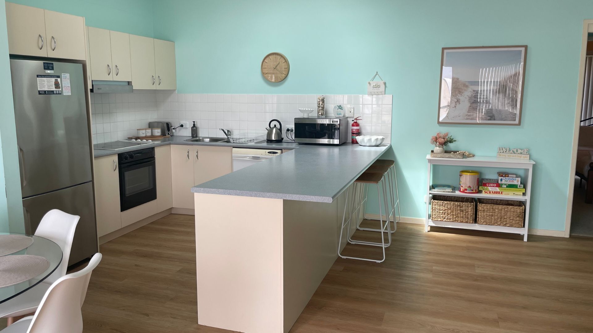 Una cocina moderna con una isla central, electrodomésticos de acero inoxidable y un salpicadero de azulejos blancos.