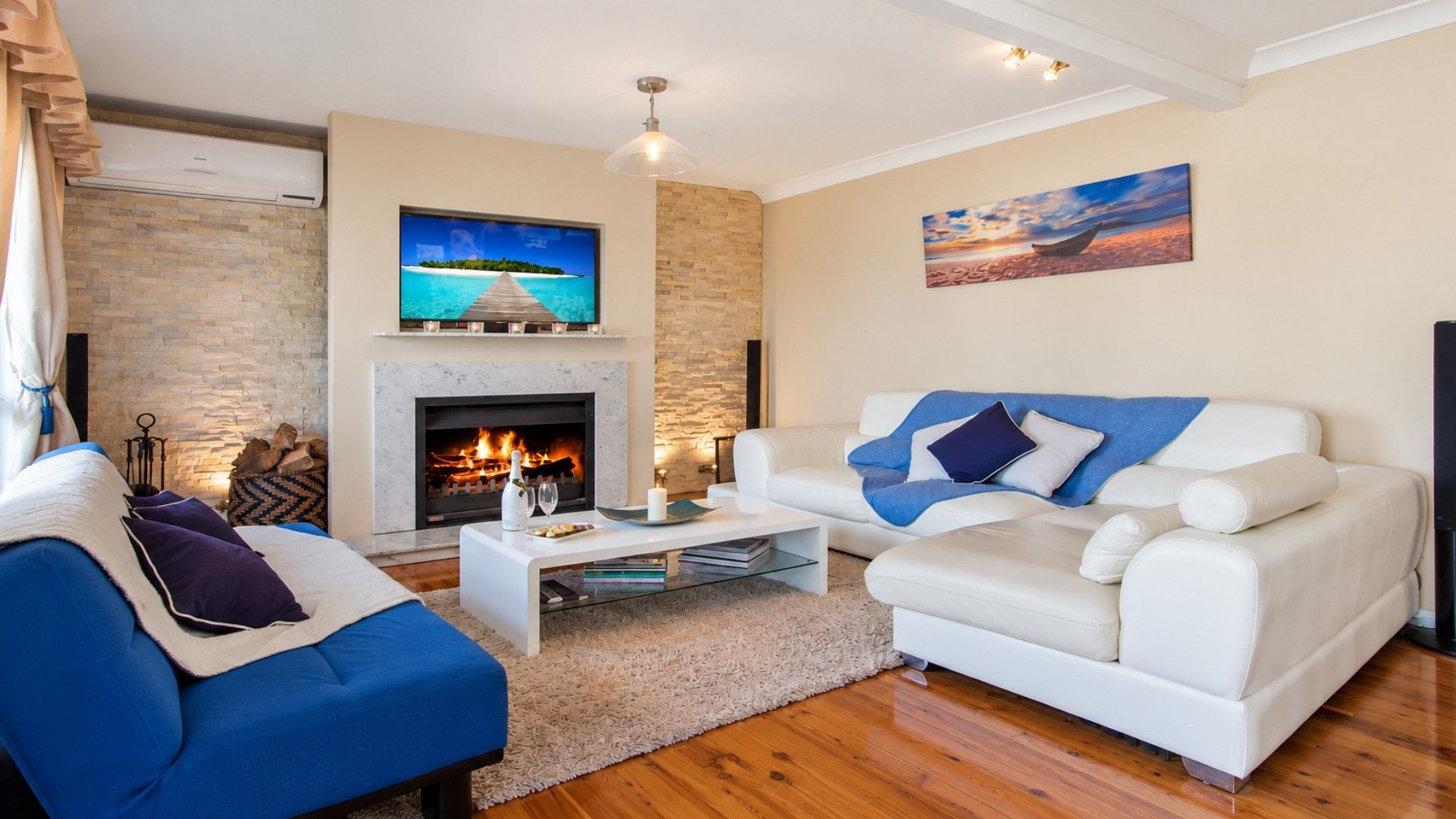 A living room with a fireplace, a sofa, a coffee table, and a television.