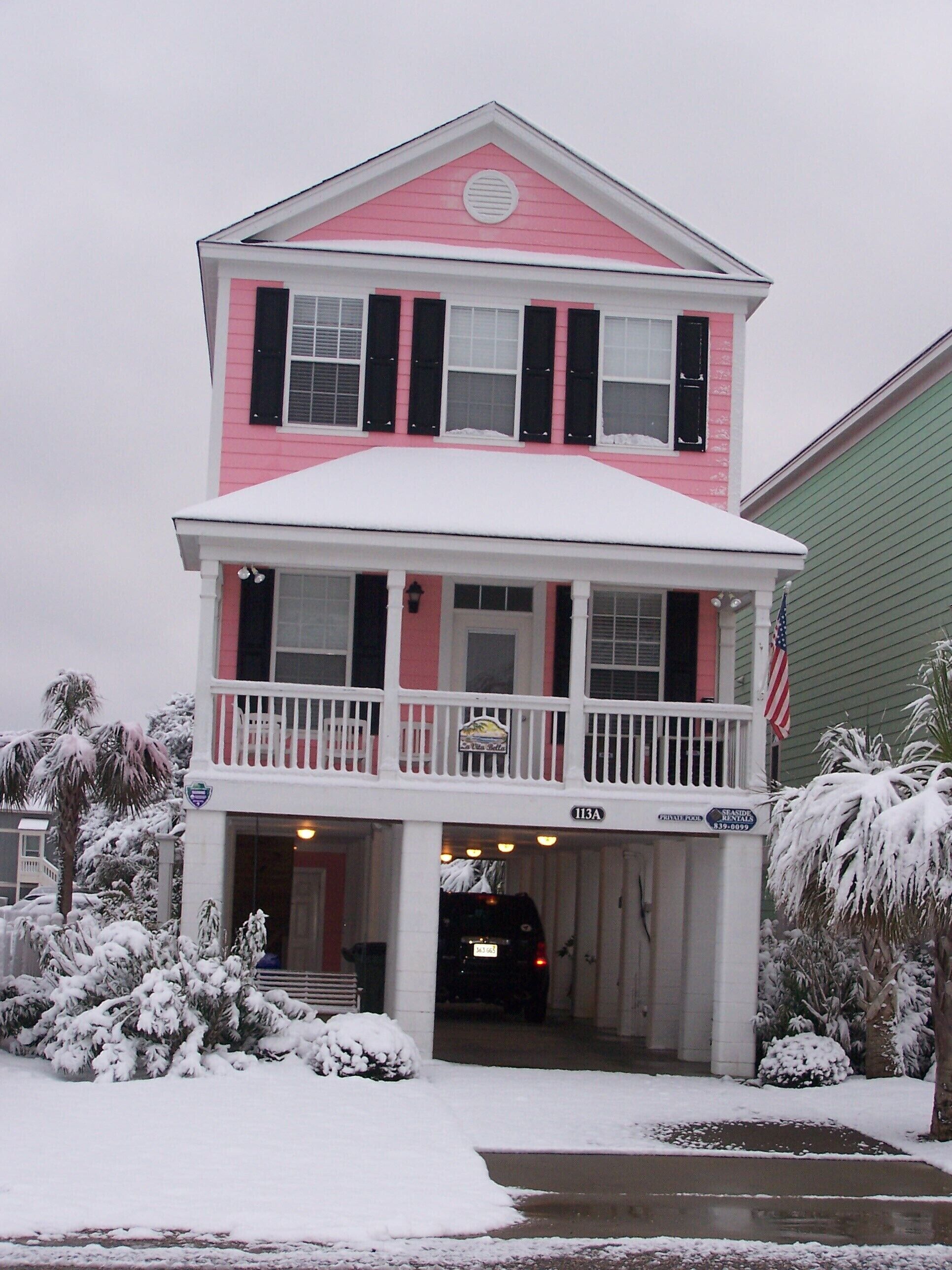 A two-story building with a balcony, a sign indicating private rooms, and an American flag.