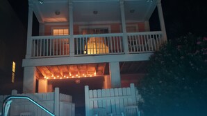 Un edificio de dos pisos con balcón y zona de piscina.