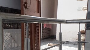 A construction site with metal scaffolding, a wooden platform, and a tiled floor. - Mohit's roof. Residential Rooftop Apartment (Delhi)