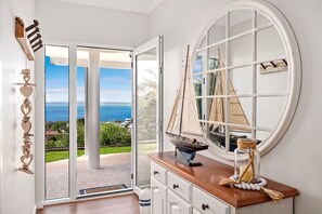 Una habitación con un ventanal grande, un modelo de velero y un adorno de madera en la pared.