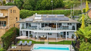 A two-story house with a balcony, solar panels, a swimming pool, and a garden. - Phuza Maningi Corlette Home with Private Pool (Corlette)