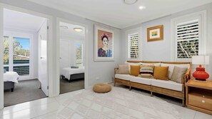 A modern living room with a sofa, a coffee table, and a painting on the wall. - Iluka @ Wrights Beach, Jervis Bay (Wrights Beach)