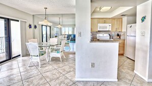A modern kitchen with a central island, white cabinetry, and a microwave. - Gorgeous Top Floor Condo w/ Water View - Pool, Pickleball, more! Land's End 4-40 (Treasure Island)