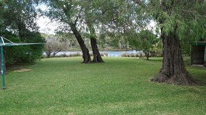 A grassy area with trees and a pond.