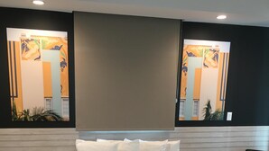 A modern hotel room with a large bed, two side tables, a sofa, and a large window with artwork. - Miami Beach 3BD Luxury Condo Suite (201) (Miami Beach)