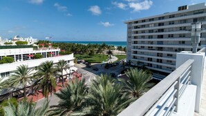 A multi-story hotel with a view of the ocean, palm trees, and a parking area. - Miami Beach 3BD Luxury Condo Suite (201) (Miami Beach)