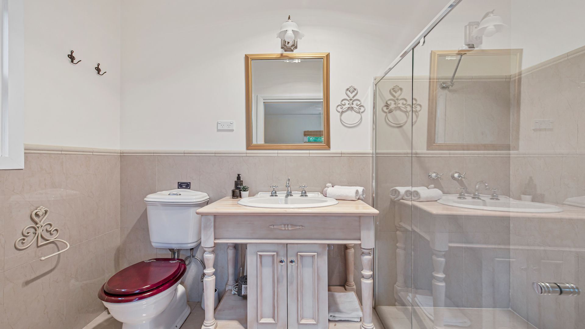 A bathroom with a toilet, sink, vanity, and shower.