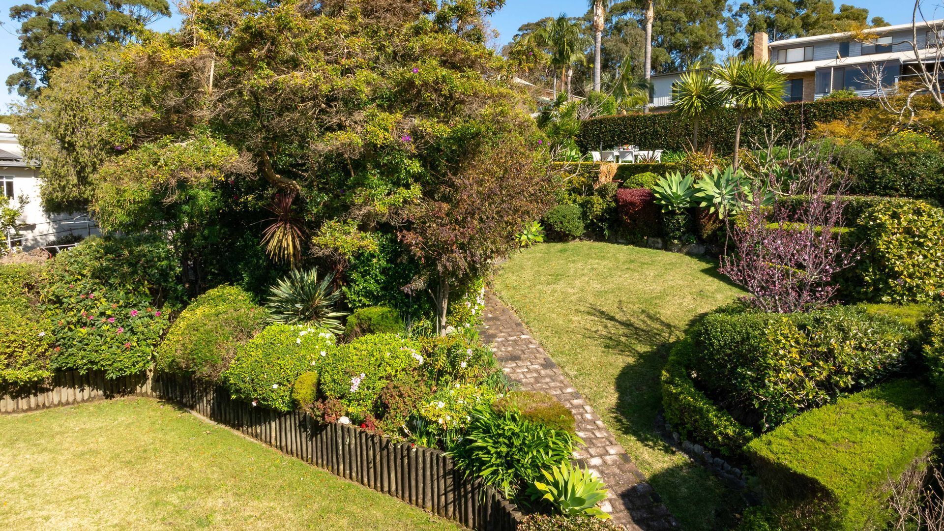 Un jardin bien entretenu, avec une grande variété de plantes et un chemin pavé de pierres.