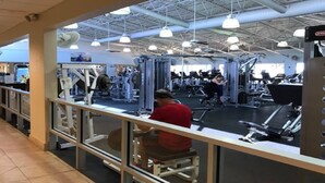 A gym with various exercise machines and a person using a treadmill. - Stuart Cottage II Pet Friendly, Remodeled, close to beach and quaint downtown (Stuart)